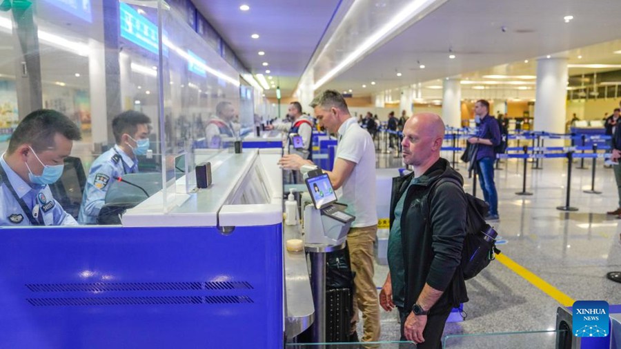 Un agente di polizia gestisce le procedure di ingresso per un passeggero dall'Australia all'aeroporto internazionale Jiangbei di Chongqing, nella Cina sud-occidentale. (2 luglio 2024 - Xinhua/Zhang Shaobo)