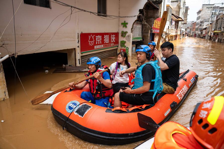 Soccorritori trasferiscono i residenti bloccati nella contea di Pingjiang, nella provincia centrale cinese dello Hunan. (2 luglio 2024 - Xinhua/Chen Sihan)