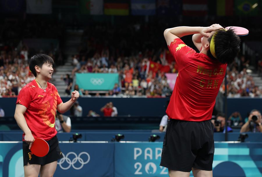 Wang Chuqin (a destra) e Sun Yingsha della Cina festeggiano la vittoria della medaglia d'oro nel doppio misto di tennistavolo ai Giochi Olimpici di Parigi 2024. (30 luglio 2024 - Xinhua/Wang Dongzhen)