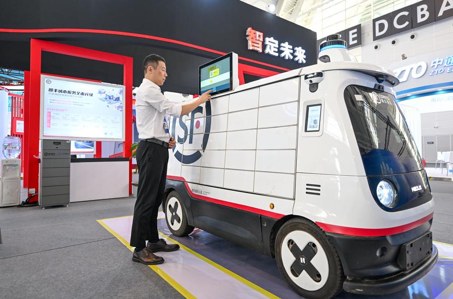 Un espositore gestisce un veicolo di consegna autonomo senza conducente per servizi di corriere esposto alla World Intelligence Expo 2024 a Tianjin, nella Cina settentrionale. (20 giugno 2024 - Xinhua/Sun Fanyue)