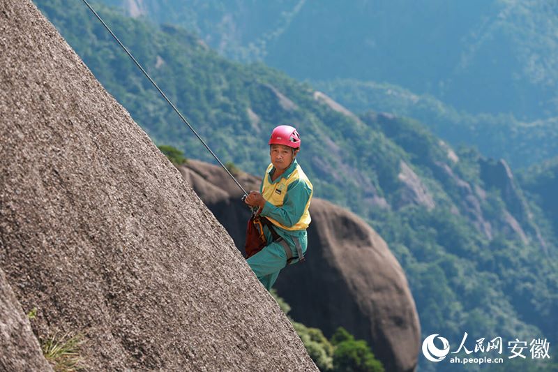 Li Peisheng al lavoro su una parete del monte Huangshan. (Quotidiano del Popolo Online/Zhang Jun)