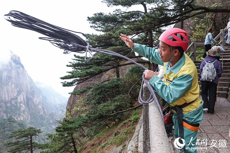 Li Peisheng al lavoro su una parete del monte Huangshan. (Quotidiano del Popolo Online/Zhang Jun)