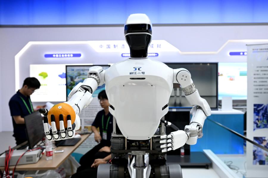 Il robot umanoide Qijiang-2 porge un'arancia a un visitatore alla World Manufacturing Convention del 2024 a Hefei, nella provincia orientale cinese dell'Anhui. (20 settembre 2024 - Xinhua/Huang Bohan)